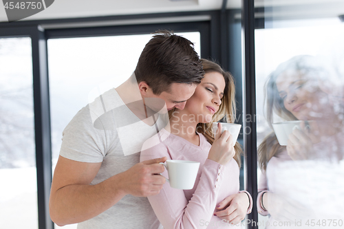 Image of young couple enjoying morning coffee by the window