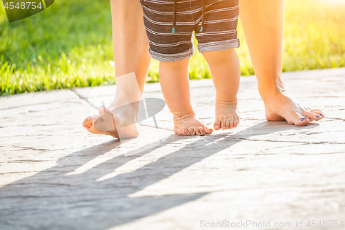 Image of Mother and Baby Feet Taking Steps Outdoors