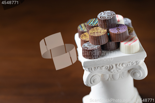 Image of Stack of Fine Artisan Chocolates Stacked On White Pillar Column