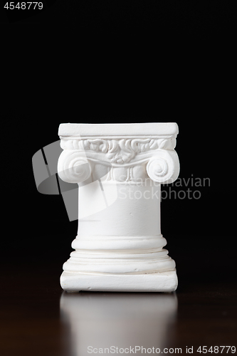 Image of White Ionic Design Column on Dark Background