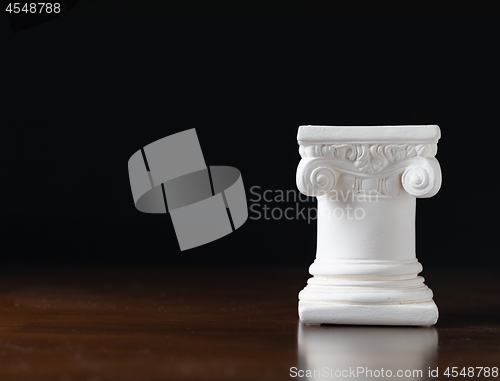Image of White Ionic Design Column on Dark Background