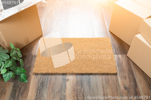 Image of Blank Welcome Mat, Moving Boxes and Plant on Hard Wood Floors