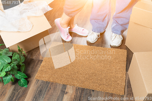 Image of Man and Woman Standing Near Home Sweet Home Welcome Mat, Moving 