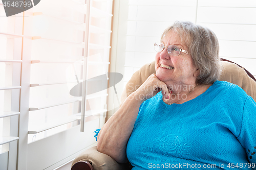 Image of Content Senior Woman Gazing Out of Her Window