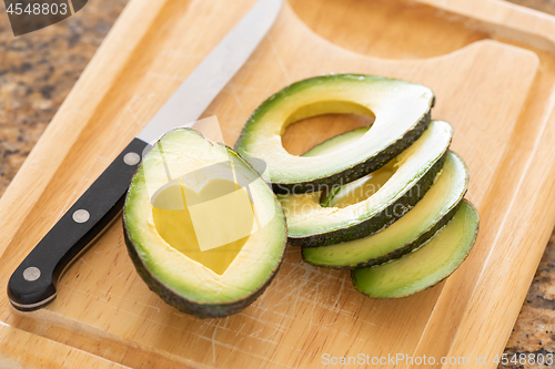 Image of Fresh Cut Avocado With Heart Shaped Pit Area On Wooden Cutting B