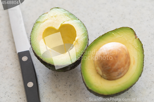 Image of Fresh Cut Avocado With Heart Shaped Pit Area On Wooden Cutting B