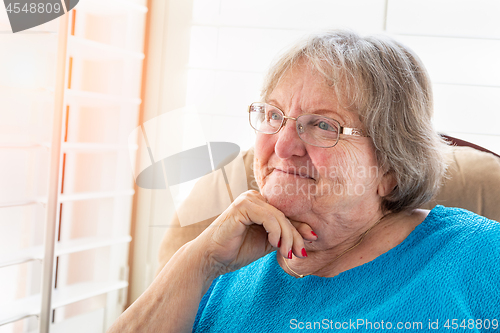 Image of Content Senior Woman Gazing Out of Her Window