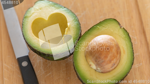 Image of Fresh Cut Avocado With Heart Shaped Pit Area On Wooden Cutting B