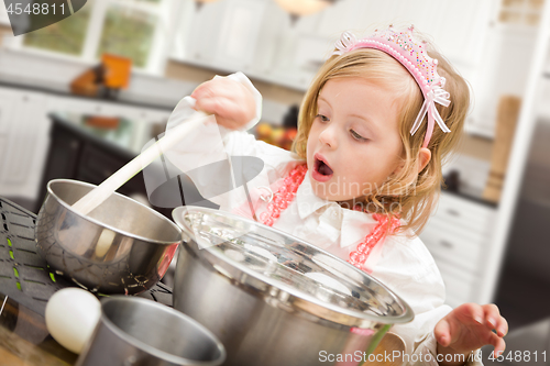 Image of Cute Baby Girl Playing Cook With Pots and Pans In Kitchen