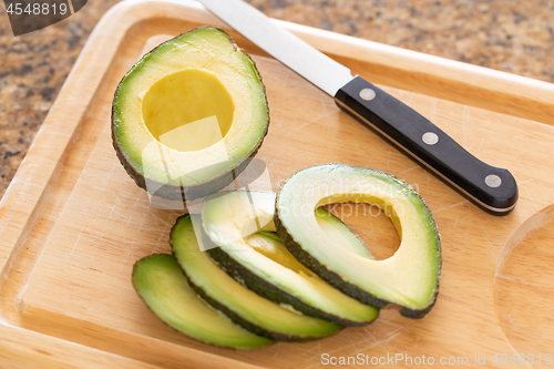 Image of Fresh Cut Avocado on Wooden Cutting Board
