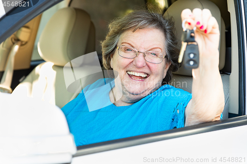 Image of Happy Senior Woman Sitting In New Car Holding The Keys