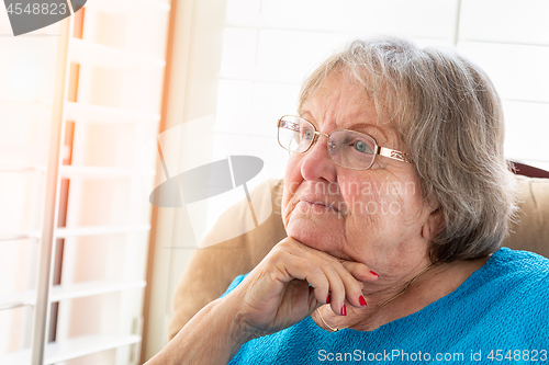 Image of Contemplative Senior Woman Gazing Out of Her Window