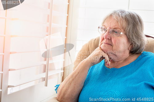 Image of Contemplative Senior Woman Gazing Out of Her Window