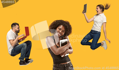 Image of The happy young jumping women and men with laptops