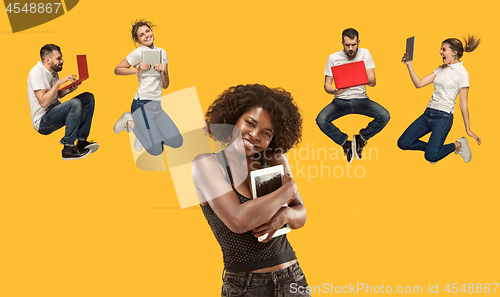 Image of The happy young jumping women and men with laptops