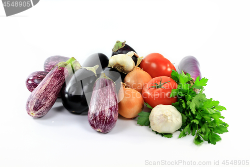 Image of Pile assorted Eggplants and vegetables on white. 