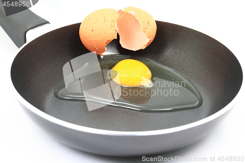 Image of Cracking organic raw egg to be fried for breakfast 