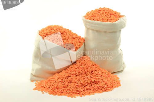 Image of Red lentils in bags and on pile.  