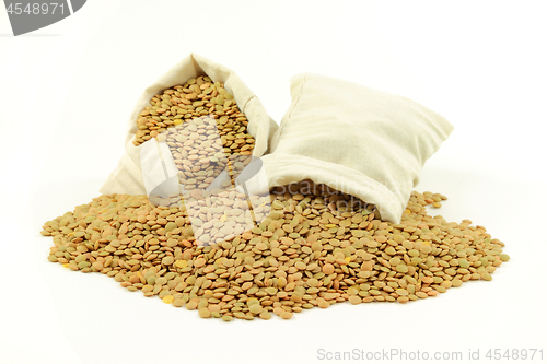 Image of Green lentils in fabric bags and on pile.  