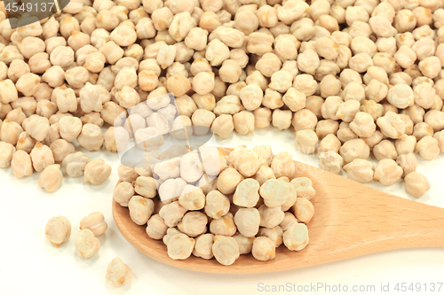 Image of Chick Peas seeds on pile and in wooden spoon. 