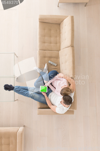 Image of young couple in living room using tablet top view