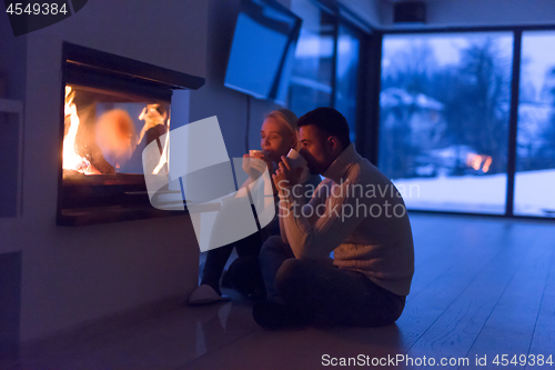 Image of happy couple in front of fireplace