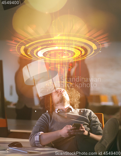 Image of businessman sitting with legs on desk at office