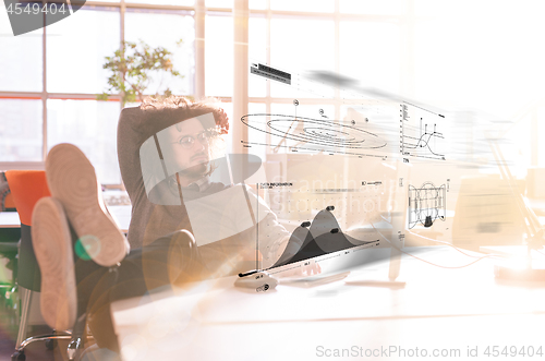 Image of businessman sitting with legs on desk