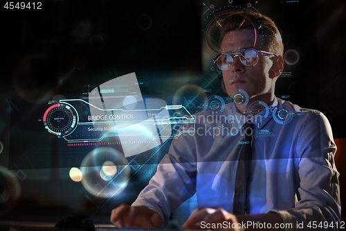 Image of man working on computer in dark office