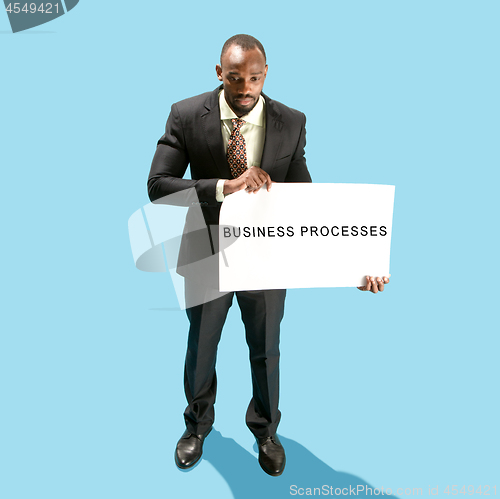 Image of Businessman holding a white poster with word business processes