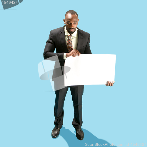 Image of Business man holding a blank banner isolated on blue background