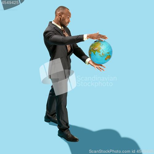 Image of Businessman holding the world in the palm of hands concept for global business, communications, politics