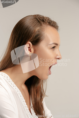 Image of The young emotional angry woman screaming on gray studio background