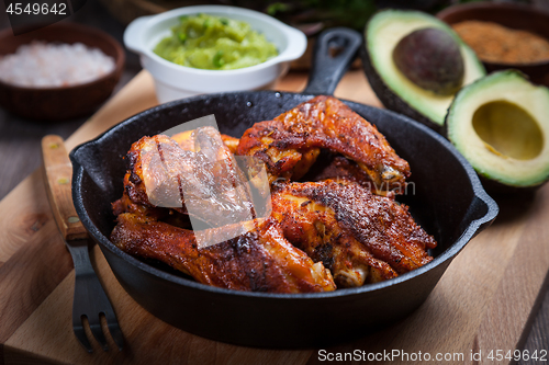 Image of Grilled hot and spicy chicken wings with guacamole