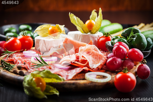 Image of Gourmet plater of party snacks presented on wooden board