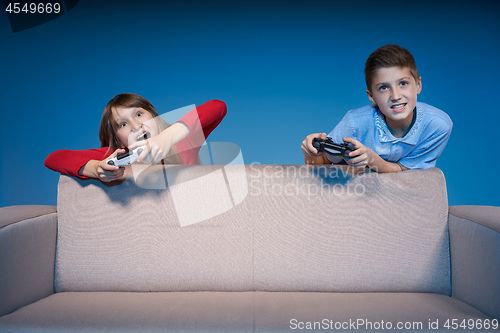 Image of Computer game competition. Gaming concept. Excited girl playing video game with joystick