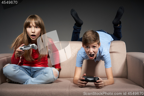 Image of Computer game competition. Gaming concept. Excited girl playing video game with joystick