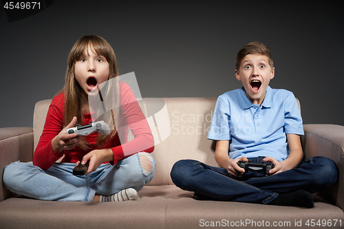 Image of Computer game competition. Gaming concept. Excited girl playing video game with joystick