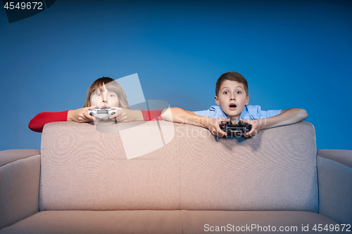 Image of Computer game competition. Gaming concept. Excited girl playing video game with joystick