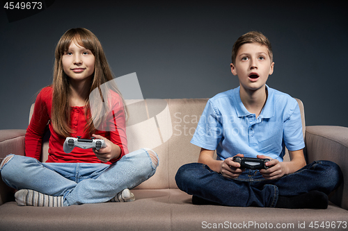 Image of Computer game competition. Gaming concept. Excited girl playing video game with joystick