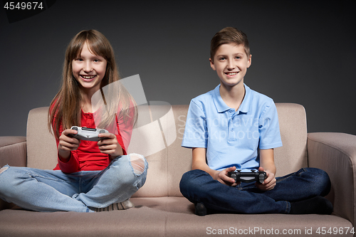 Image of Computer game competition. Gaming concept. Excited girl playing video game with joystick