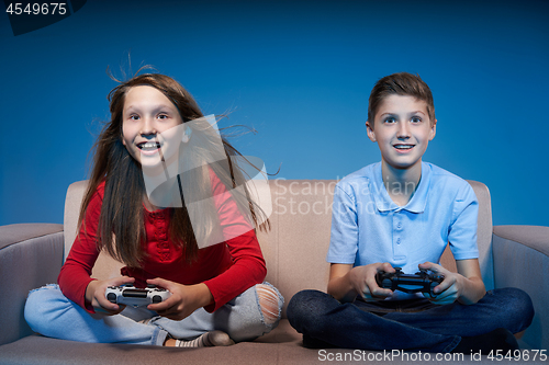 Image of Computer game competition. Gaming concept. Excited girl playing video game with joystick