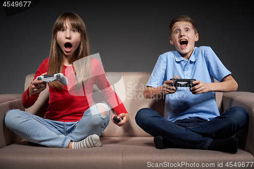 Image of Computer game competition. Gaming concept. Excited girl playing video game with joystick