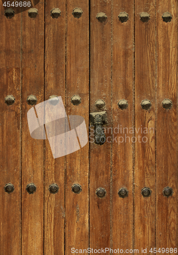 Image of Ancient Wooden Door with Rivets and Door Knocker