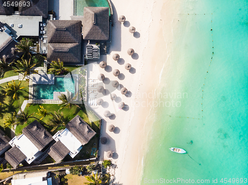 Image of Aerial view of amazing tropical white sandy beach with palm leaves umbrellas and turquoise sea, Mauritius.