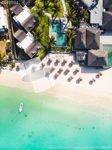 Image of Aerial view of amazing tropical white sandy beach with palm leaves umbrellas and turquoise sea, Mauritius.