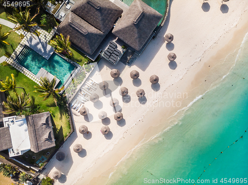 Image of Aerial view of amazing tropical white sandy beach with palm leaves umbrellas and turquoise sea, Mauritius.