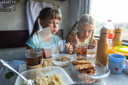 Image of Two girls have lunch in the reserved seat of the train