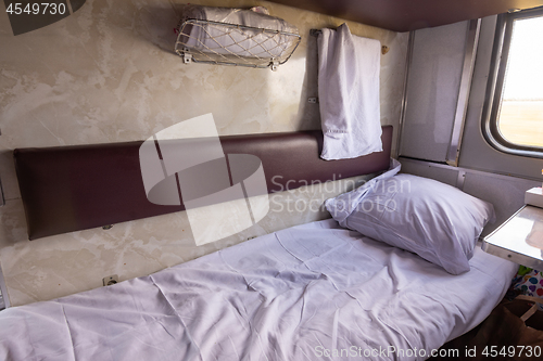 Image of General view of the empty lower shelf of the reserved seat carriage of the train, spread bedding