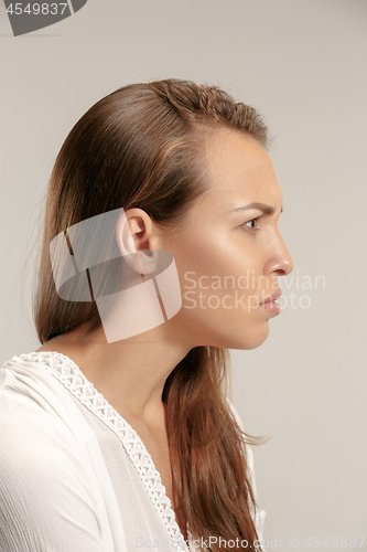 Image of Portrait of an angry woman looking at camera isolated on a gray background